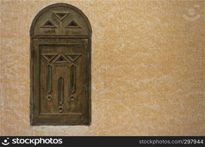 Wooden window in the Arab style on the background of textured wall