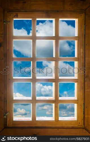 Wooden window with beautiful view to blue sky and clouds