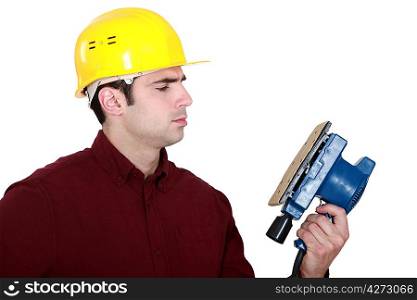 Woodworker looking at a sander