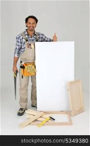 Woodworker stood with cabinet door and advertising panel