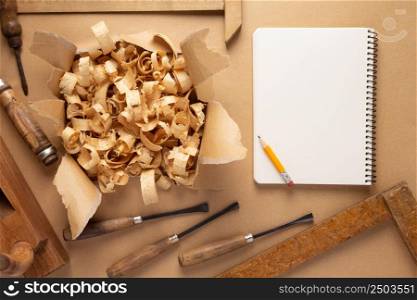 Woodworking carpenter chisel tool and wood shavings at paper background. Chisel as joiner tool