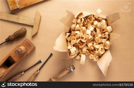 Woodworking carpenter chisel tool and wood shavings  on paper background. Chisel as joiner tool