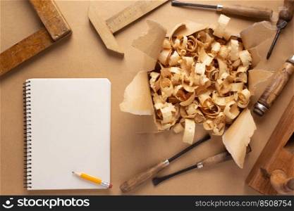 Woodworking carpenter chisel tool and wood shavings  on paper background. Chisel as joiner tool