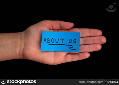 Word About us on blue paper and hand