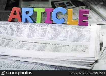 Word article on newspaper. Wooden letters