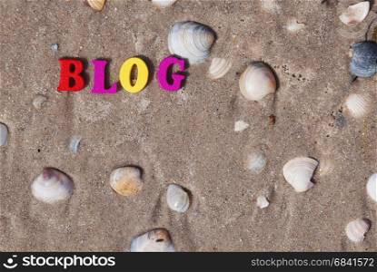 Word blog of multicolored wooden letters on sand with seashells, top view