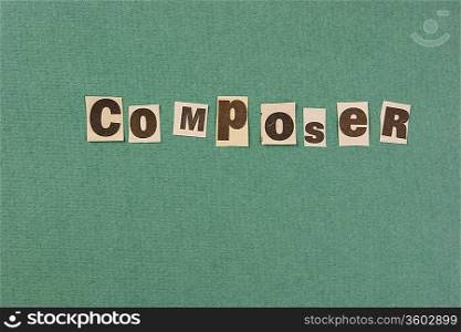 word composer cut from newspaper on green background