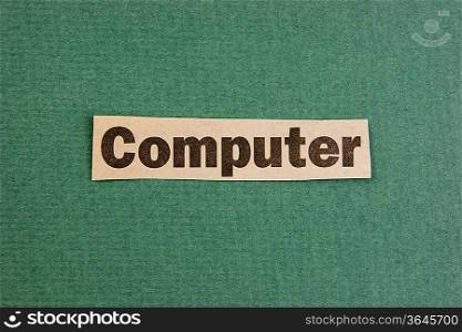 word computer cut from newspaper on green background