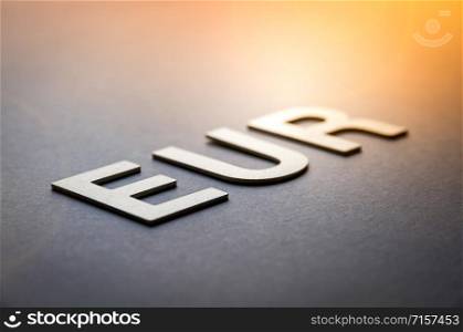 Word EUR written with white solid letters on a board. Word EUR written with white solid letters