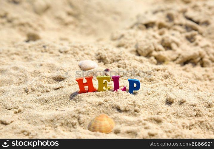 Word help from multicolored wooden letters on sand of sea beach