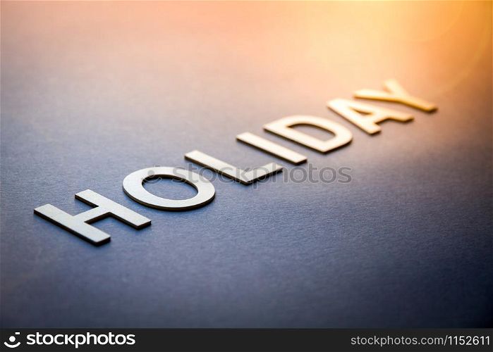Word holiday written with white solid letters on a board. Word holiday written with white solid letters
