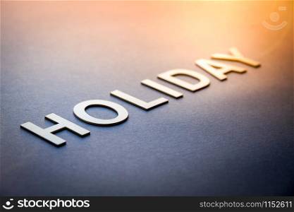 Word holiday written with white solid letters on a board. Word holiday written with white solid letters