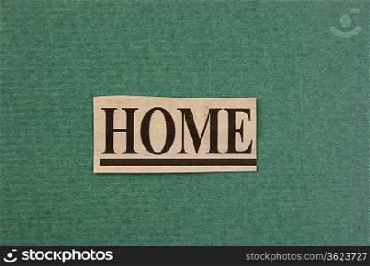 word home cut from newspaper on green background