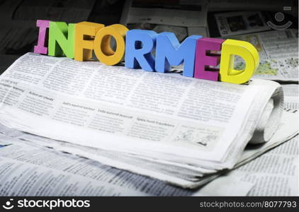 Word informed on newspaper. Wooden letters