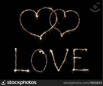 word love and two hearts from sparkler isolated on black background