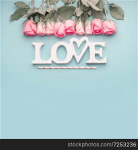 Word love with roses border on pastel blue background, top view with copy space . Valentines day or abstract love concept