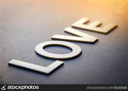 Word love written with white solid letters on a board. Word love written with white solid letters