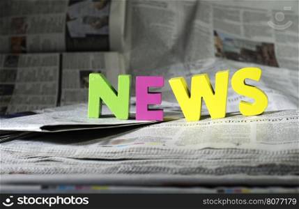 Word news on newspaper. Wooden letters