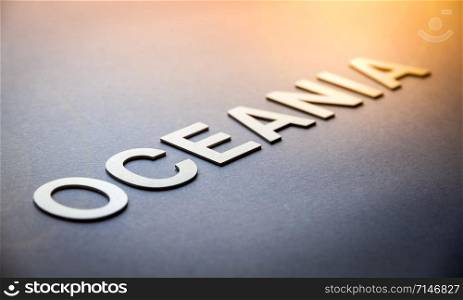 Word Oceania written with white solid letters on a board. Word Oceania written with white solid letters