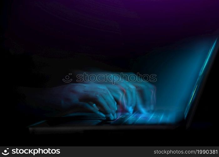 Word of Mouth, Power on the Internet Concept. Motion Blurred image of Hand Using Computer Laptop Keyboard on Desk in Dark Room. Working Fast at Night
