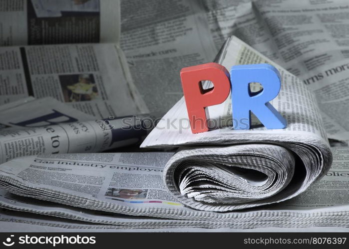 Word PR on newspaper. Wooden letters