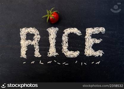 Word rice written with white grains on black slate board. Word rice written on slate