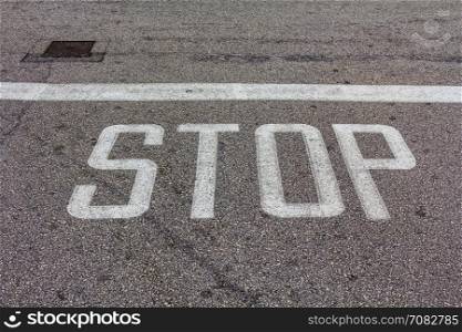 Word Stop written on an asphalt road, Top view on the road in perspective