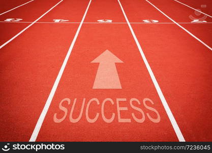 "word "SUCCESS" and athletic track number on red rubber racetrack, texture of runnin."