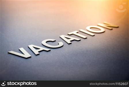 Word vacation written with white solid letters on a board. Word vacation written with white solid letters