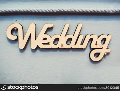 "Word "wedding" on wooden background"