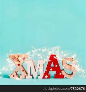 Word Xmas with copy space and holiday bokeh on blue background. Festive Christmas concept. Greeting card, invitation or sale layout
