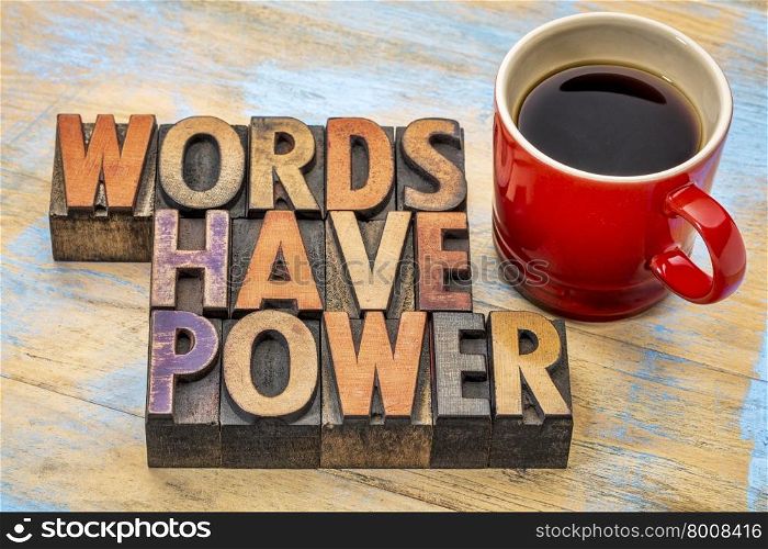 words have power phrase in vintage letterpress wood type printing blocks stained by color inks with a cup of coffee