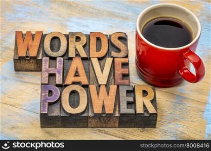 words have power phrase in vintage letterpress wood type printing blocks stained by color inks with a cup of coffee