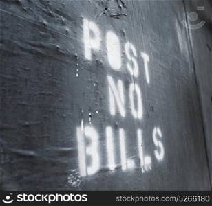 "Words "Post No Bills" sprayed on an old wall."