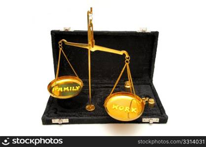 Work And Family In Balance. Conceptual image of keeping the job and family in balance in a busy and stressful world using a brass balance scale with yellow letters to spell out the concept