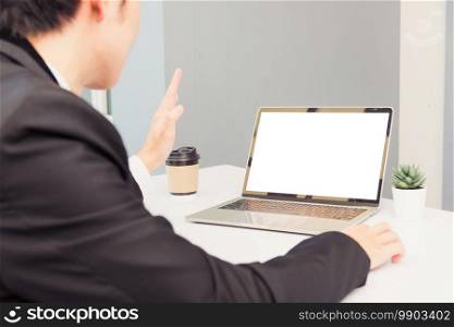 Work from home, Asian young businessman smile wearing suit video conference call or facetime by laptop computer raise your hand to say hello on desk at home office
