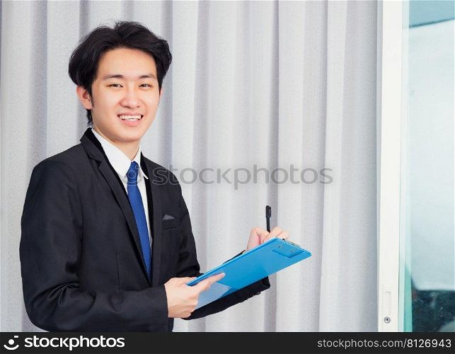 Work from home, Asian young businessman video conference call or facetime he smiling write notebook information at the home office