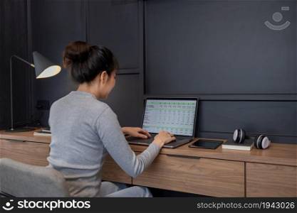Work from home concept a young girl with a bun hair doing her remote work in her bedroom.