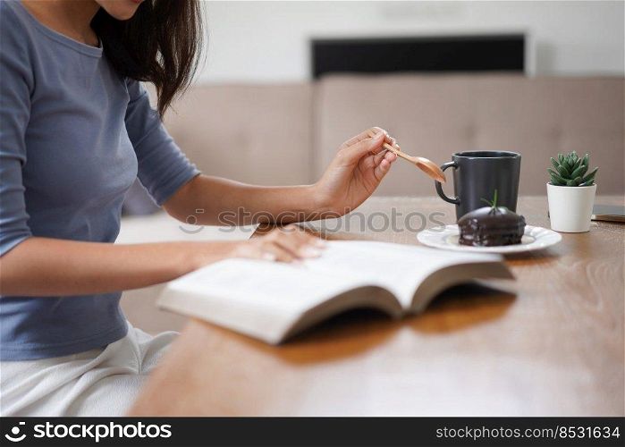 Work from home concept, Business women eats dessert and reads book to relax after working at home.