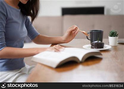 Work from home concept, Business women eats dessert and reads book to relax after working at home.