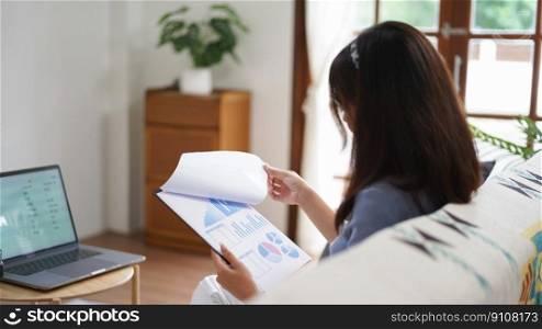Work from home concept, Business women reading chart financial data while working remotely at home.