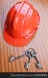 work helmet and keys on the table of a office