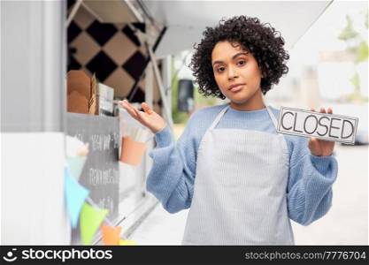 work, job and people concept - woman in apron holding closed sign over food truck on street background. woman in apron holding closed sign over food truck