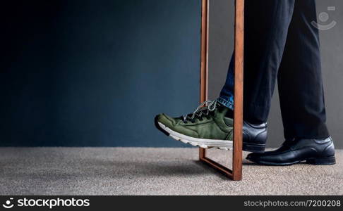 Work Life Balance Concept. Challenging to Change. Low Section of Businessman Steps passing a wooden frame. Half is a Formal Dress and other side is a Casual Traveling Shoes
