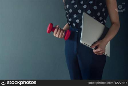 Work Life Balance Concept, present by Business Working Woman holding a Laptop and Dumbbell, Lifestyle of Modern People. Croped image with Copy Space