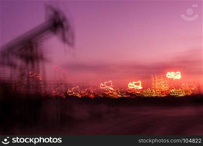 Work of oil pump jack on a oil field and brightly lit industrial site. Blurred motion. Concept oil and gas industry.. Oil and gas industry background.