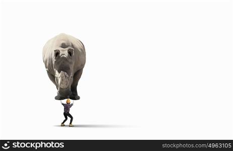 Work on forces. Businesswoman carrying big rhino on her back