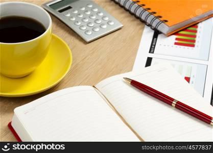 Work place at office with cup of coffee and stationary. Coffee with notepad and pen