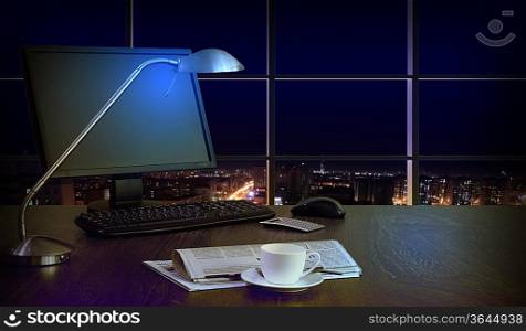Work place in the office at night with a city view from window