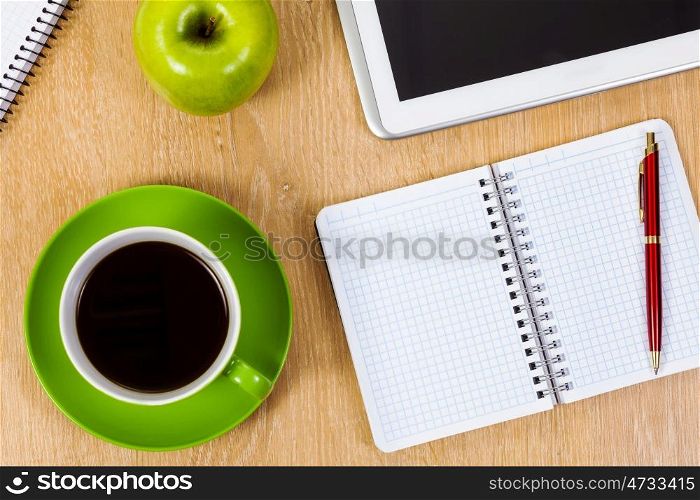 Work place. Tablet pc cup of coffee and notepad at table